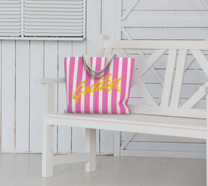 Our signature stripes luxe tote shown in a bold pink and yellow with the word "Goddess" on the bag, features 2 interior pockets and a navy blue lining.