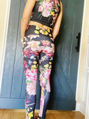 A deep black midnight acts as the background for brilliant beautiful florals on these compression leggings