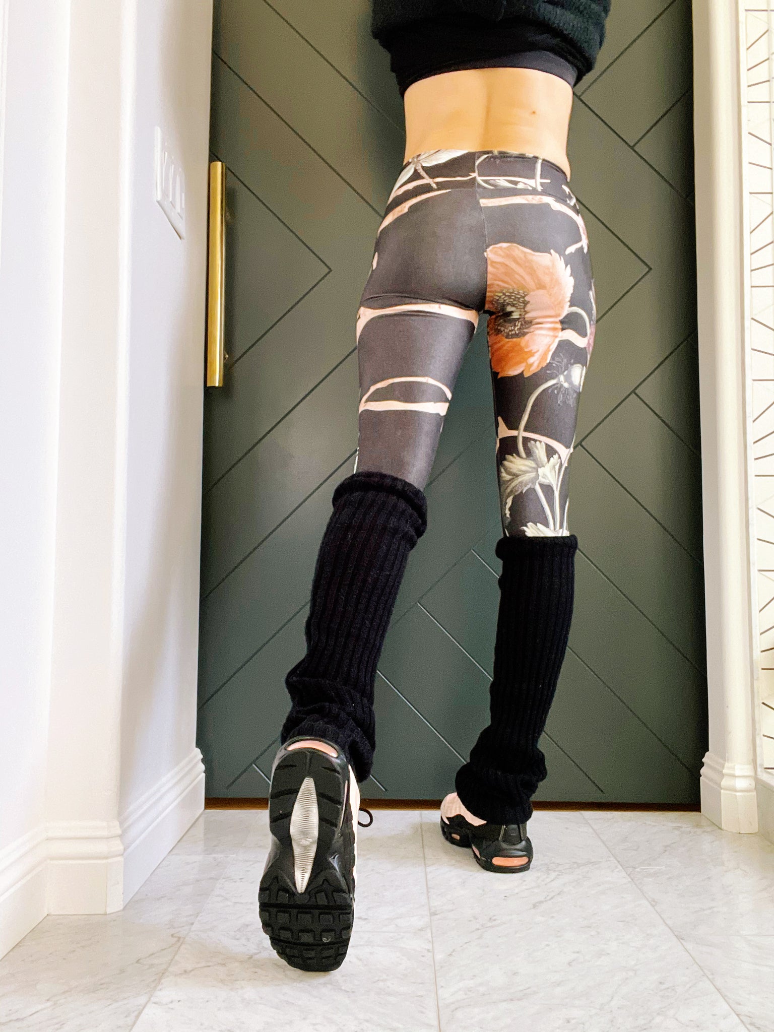 Black knee high leg warmers with a Signature Sweat Goddess tag on one leg