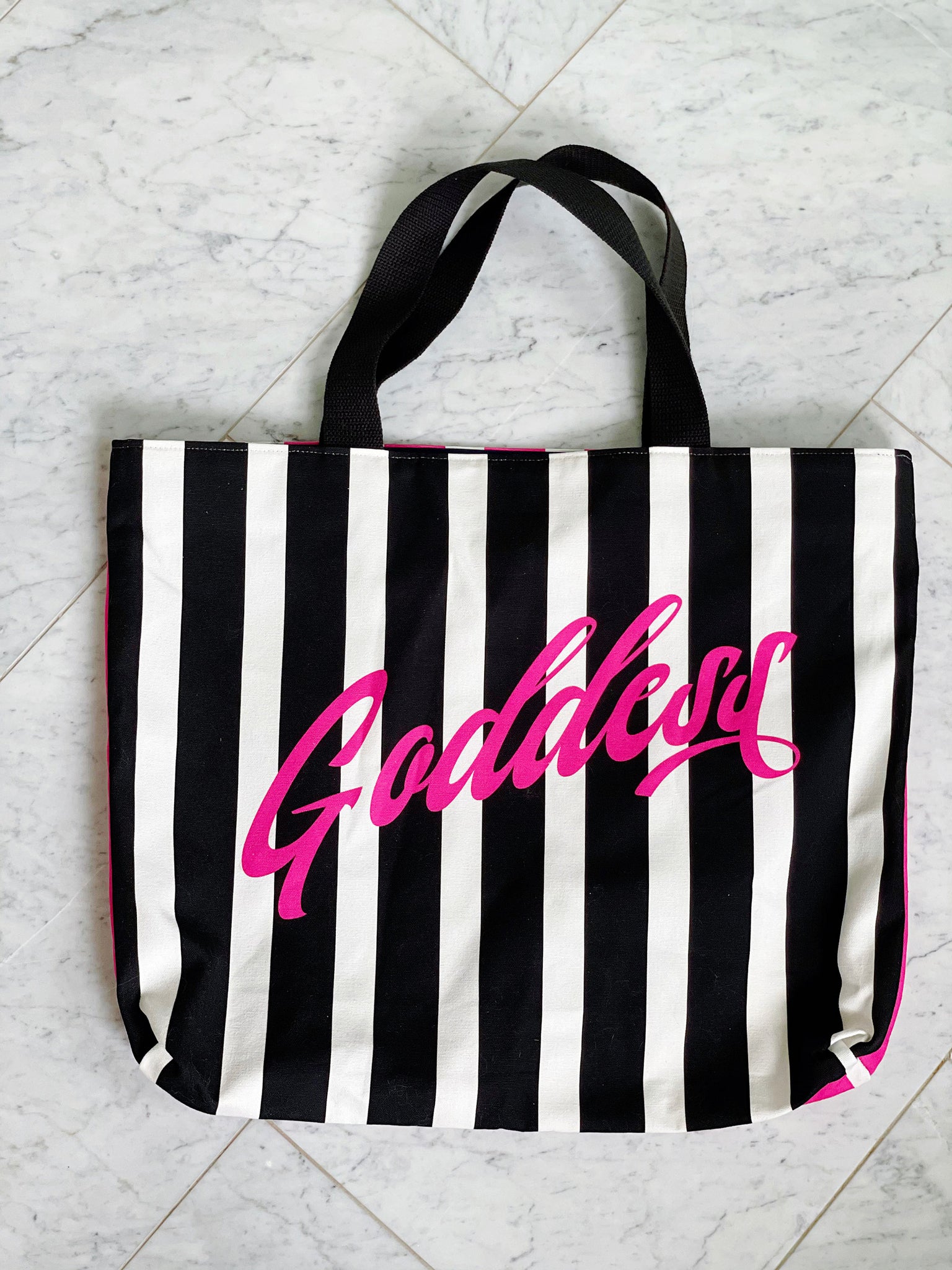 Black and pink striped luxe tote bag with the word "Goddess" featured. Fully lined with 2 interior pockets and a magnetic closure.