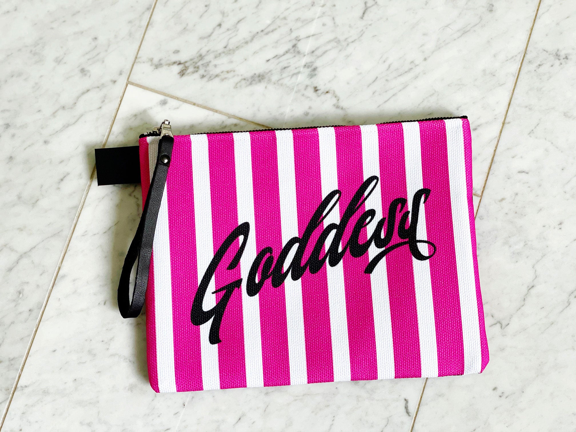 fully lined 10" zipper pouch in pink and black stripes with the word Goddess in script