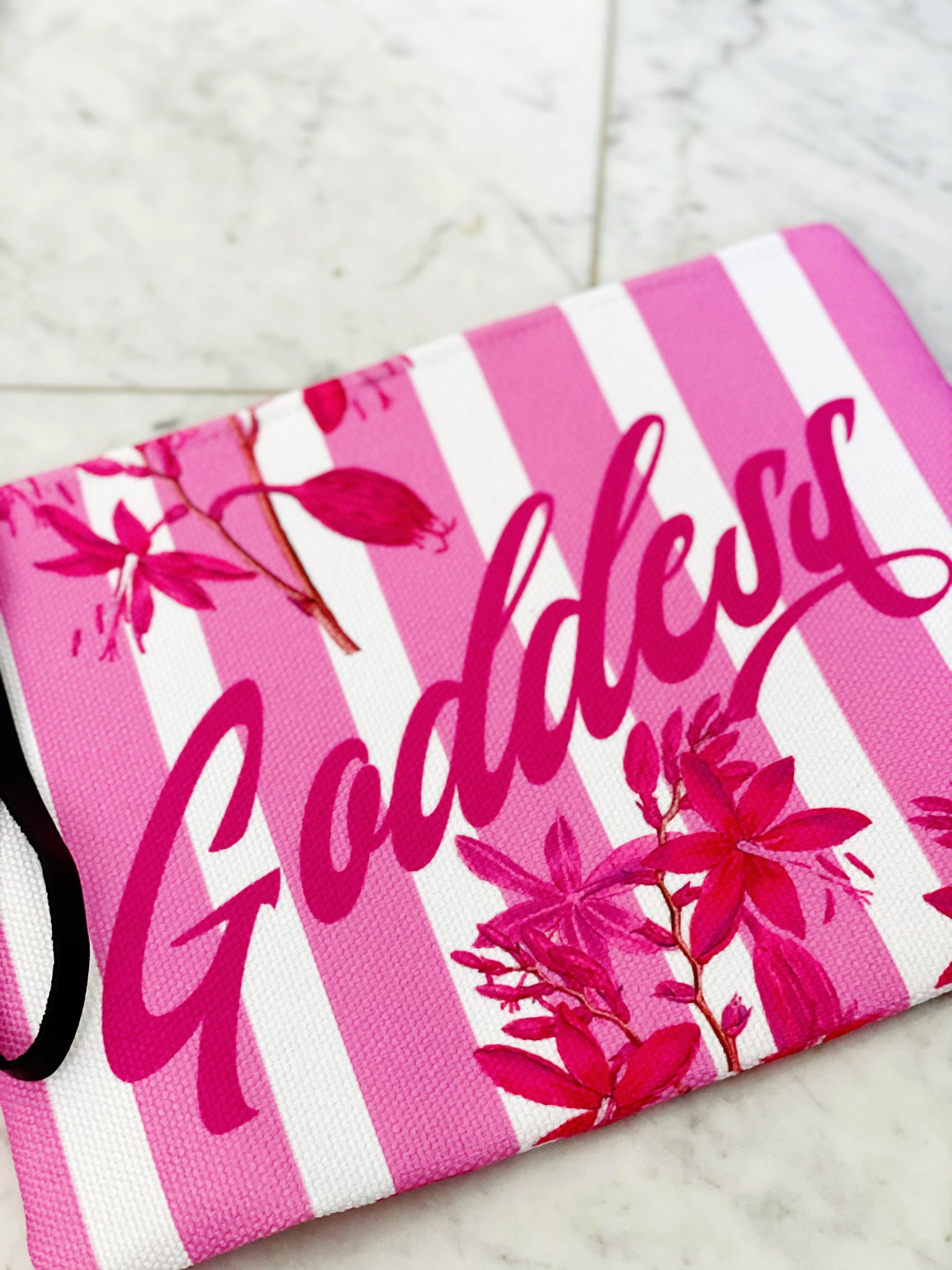 Luxe canvas pouch, fully lined with vegan leather details, featuring our pink stripes and florals print with the word "Goddess" on the front.