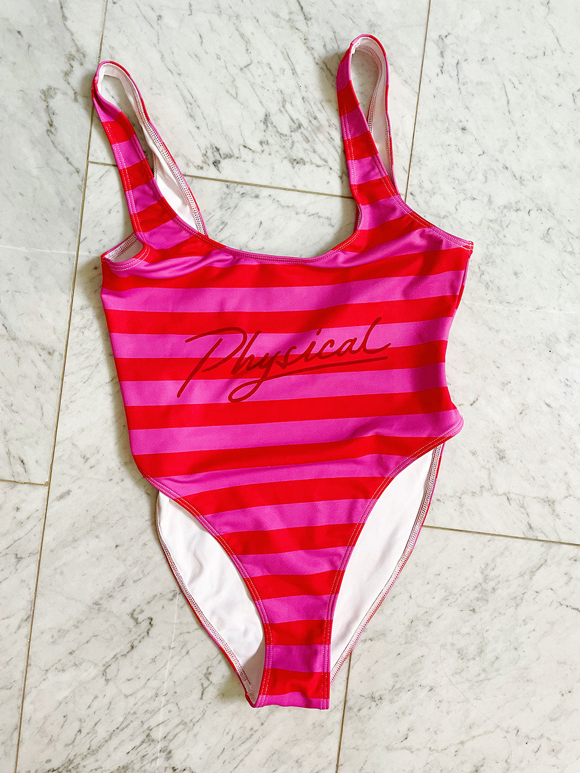 Retro swim/body suit in pink and red stripes with the word physical on the front.