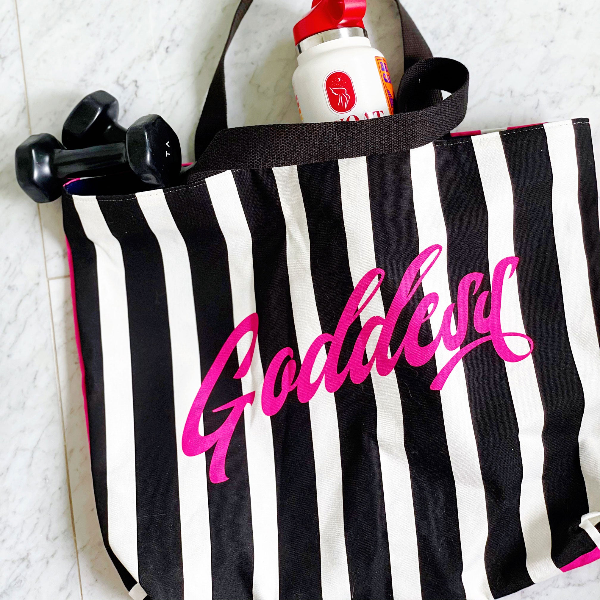 Black and pink striped luxe tote bag with the word "Goddess" featured. Fully lined with 2 interior pockets and a magnetic closure.