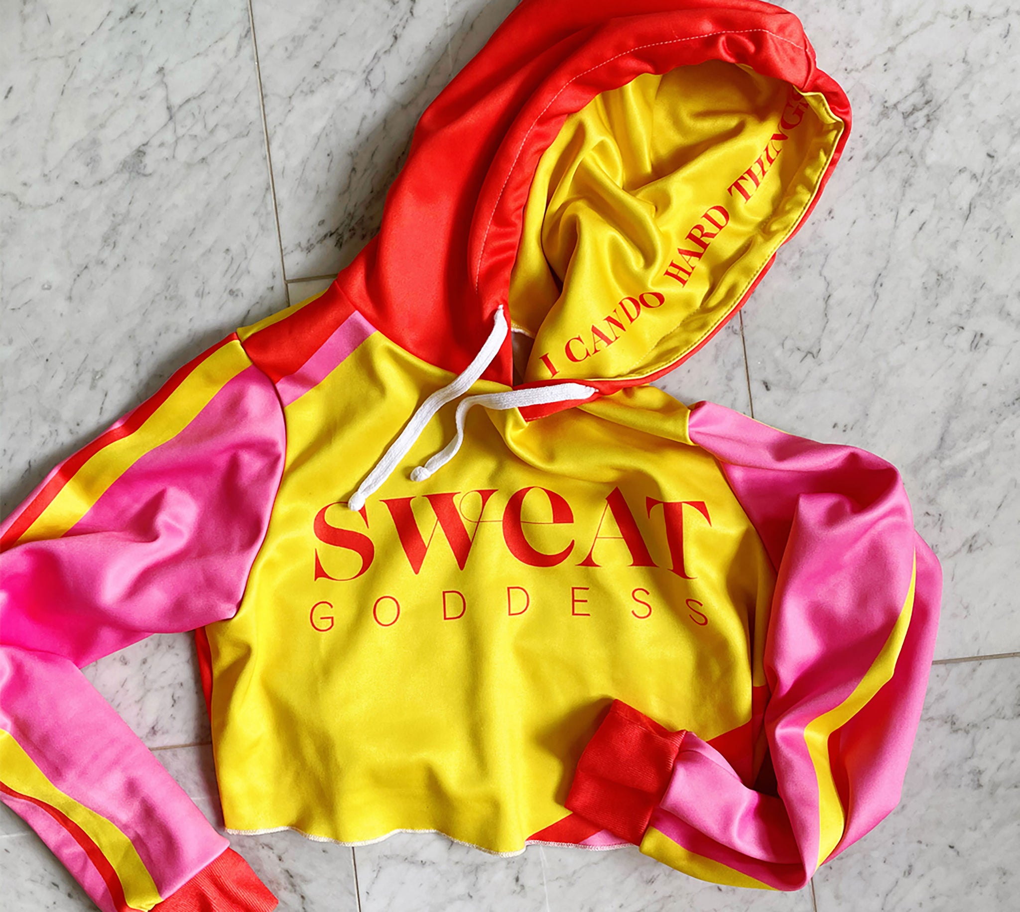 Bold yellow red and pink color blocking adorn this crop hoodie