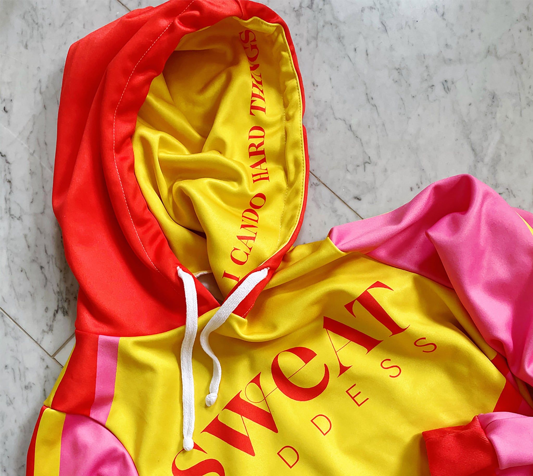 Bold yellow red and pink color blocking adorn this crop hoodie