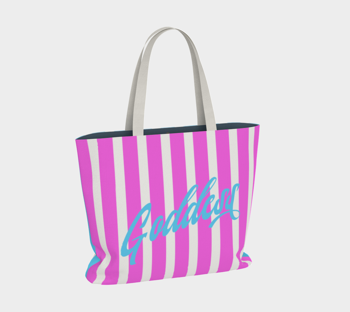 Our signature stripes luxe tote shown in a bold pink and blue with the word "Goddess" on the bag, features 2 interior pockets and a navy blue lining.