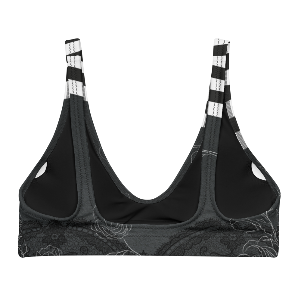 A dark night with delicate floral drawings and black and white bold stripe details adorn this bikini/sports bra.