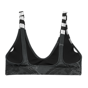 A dark night with delicate floral drawings and black and white bold stripe details adorn this bikini/sports bra.