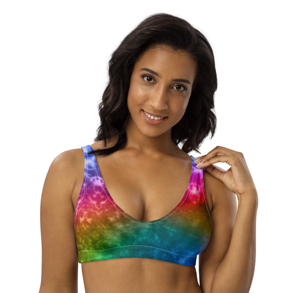 Recycled bikini sports bralette with removable pads with a vibrant rainbow tie dye printRecycled bikini sports bralette with removable pads shown in an electric rainbow tie dye print.