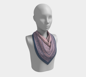 This silk scarf features contrasting patterns in pink and navy with a beautiful floral in the center.